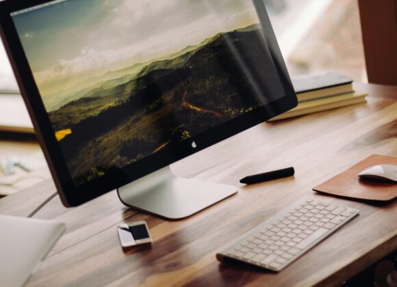 space gray iMac near Magic Keyboard on brown wooden computer desk during daytime